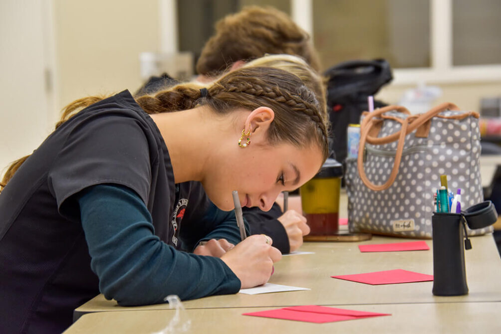 Biomed student writing thank you note to her mentor