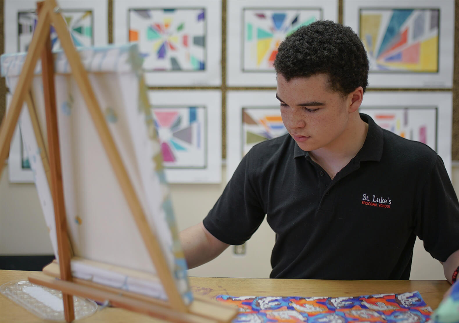 St. Luke's art student paints on an easel